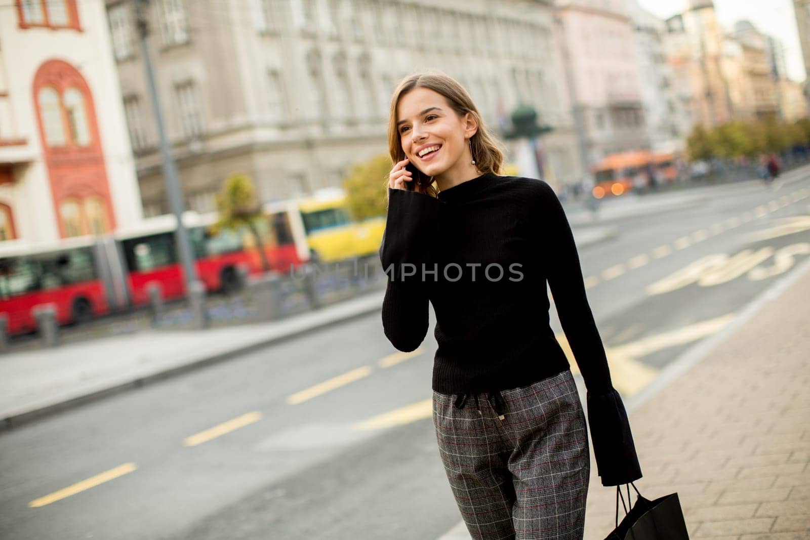 Portrait of young woman waiting for taxi or bus on the street in the city