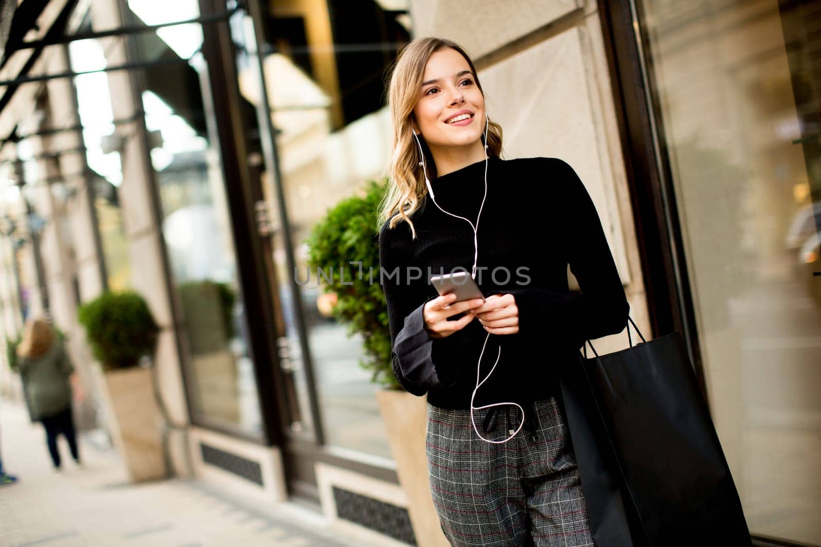Portrait of modern young shopaholic woman on street