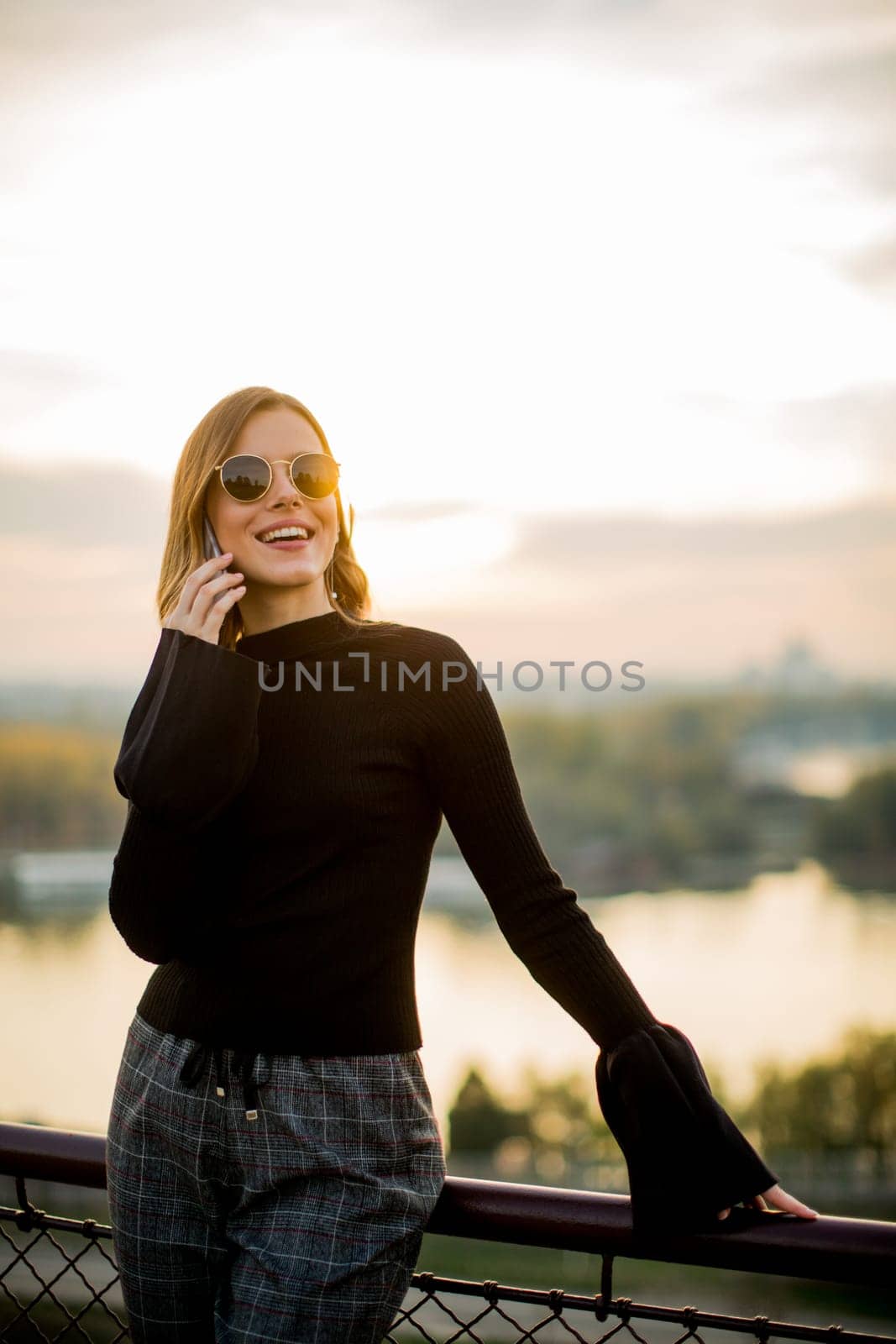 Portrait of young woman with mobile phone outdoor
