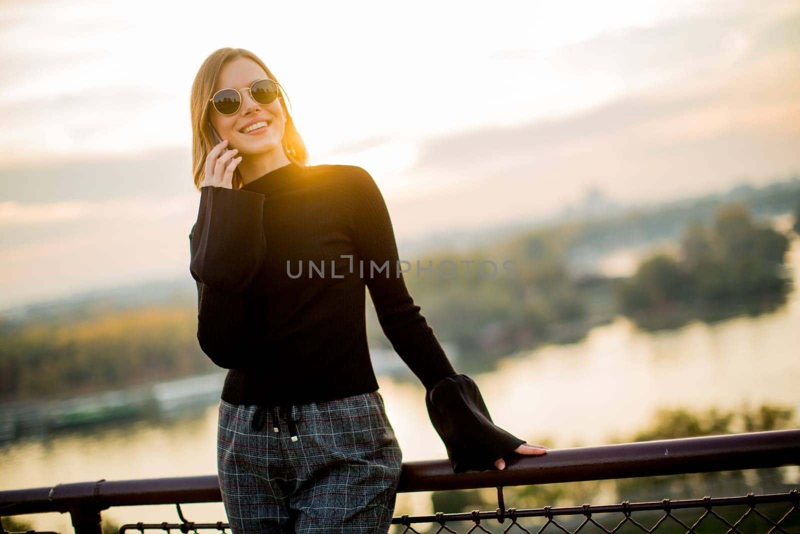 Portrait of young woman with mobile phone outdoor