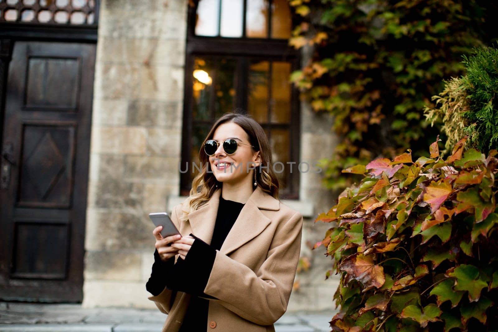 View at modern woman using mobile phone at autumn outdoor