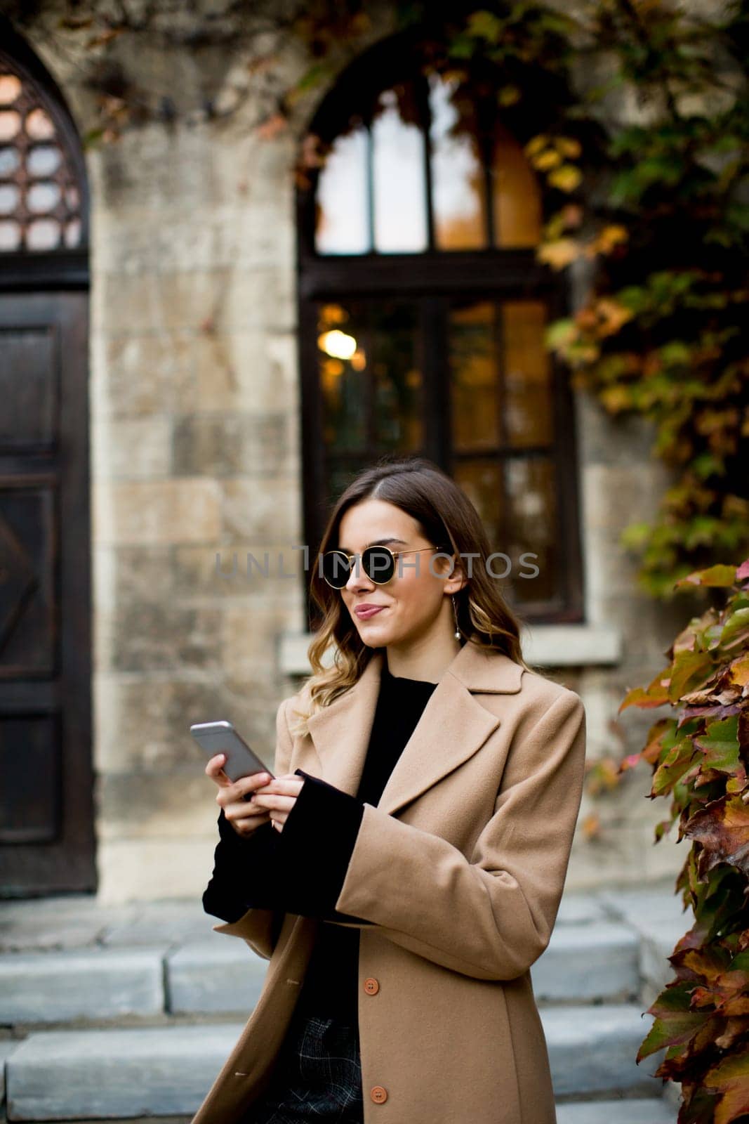 View at modern woman using mobile phone at autumn outdoor