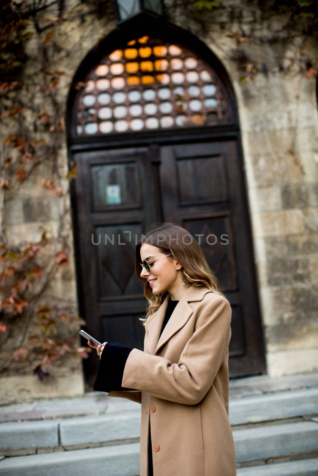 View at modern woman using mobile phone at autumn outdoor