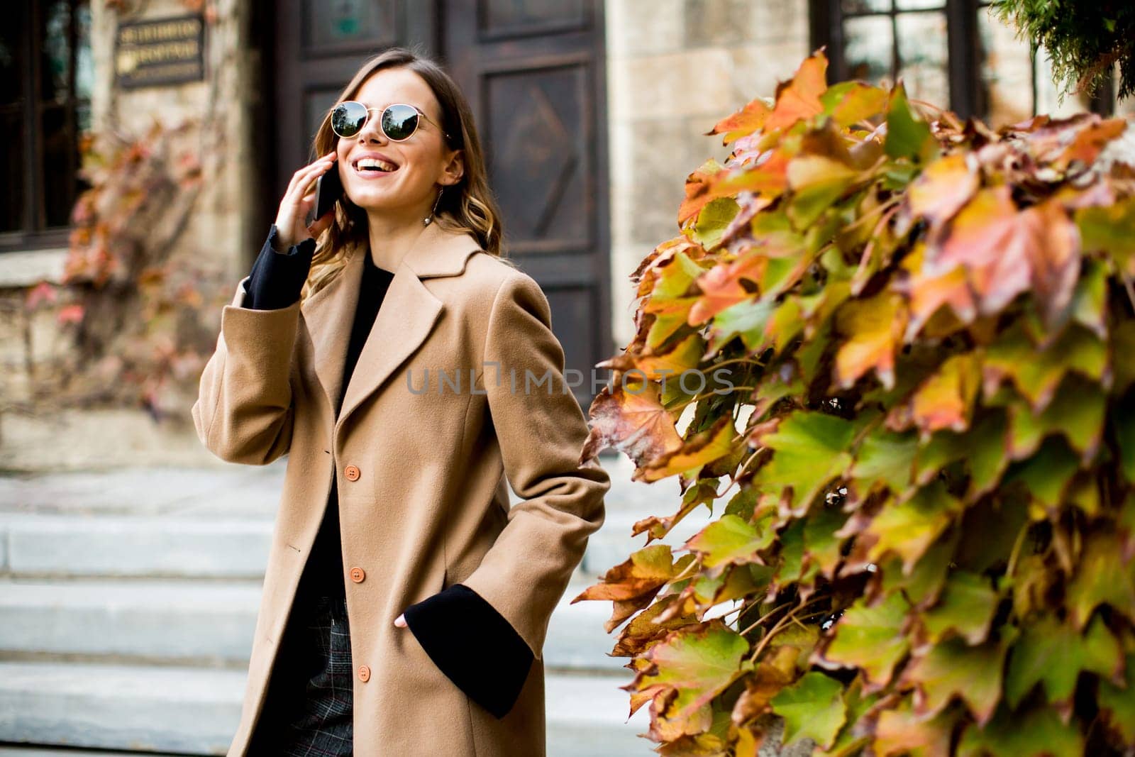 View at modern woman using mobile phone at autumn outdoor