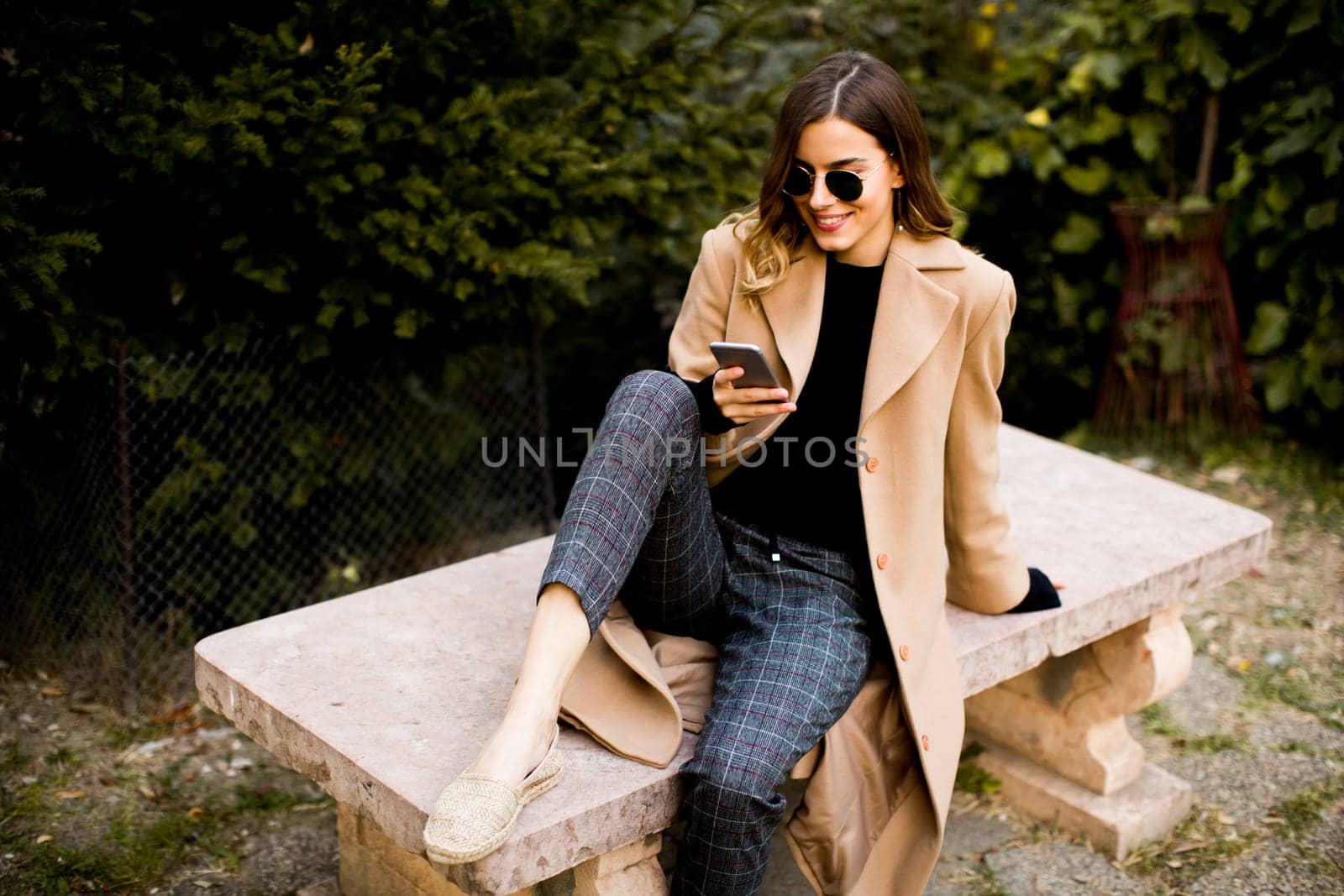 View at modern woman using mobile phone at autumn outdoor