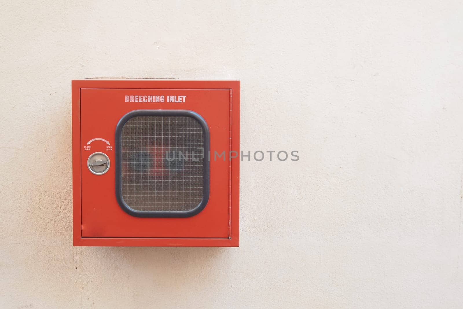 Fire safety equipment mounted on a white wall in a public area.