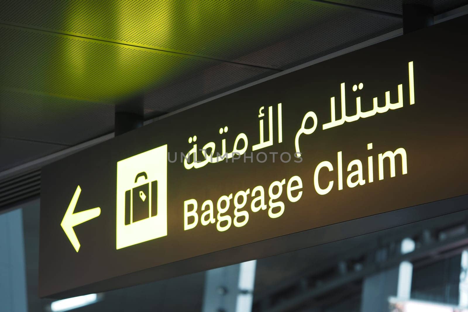 Directional sign indicating baggage claim area inside the airport terminal.