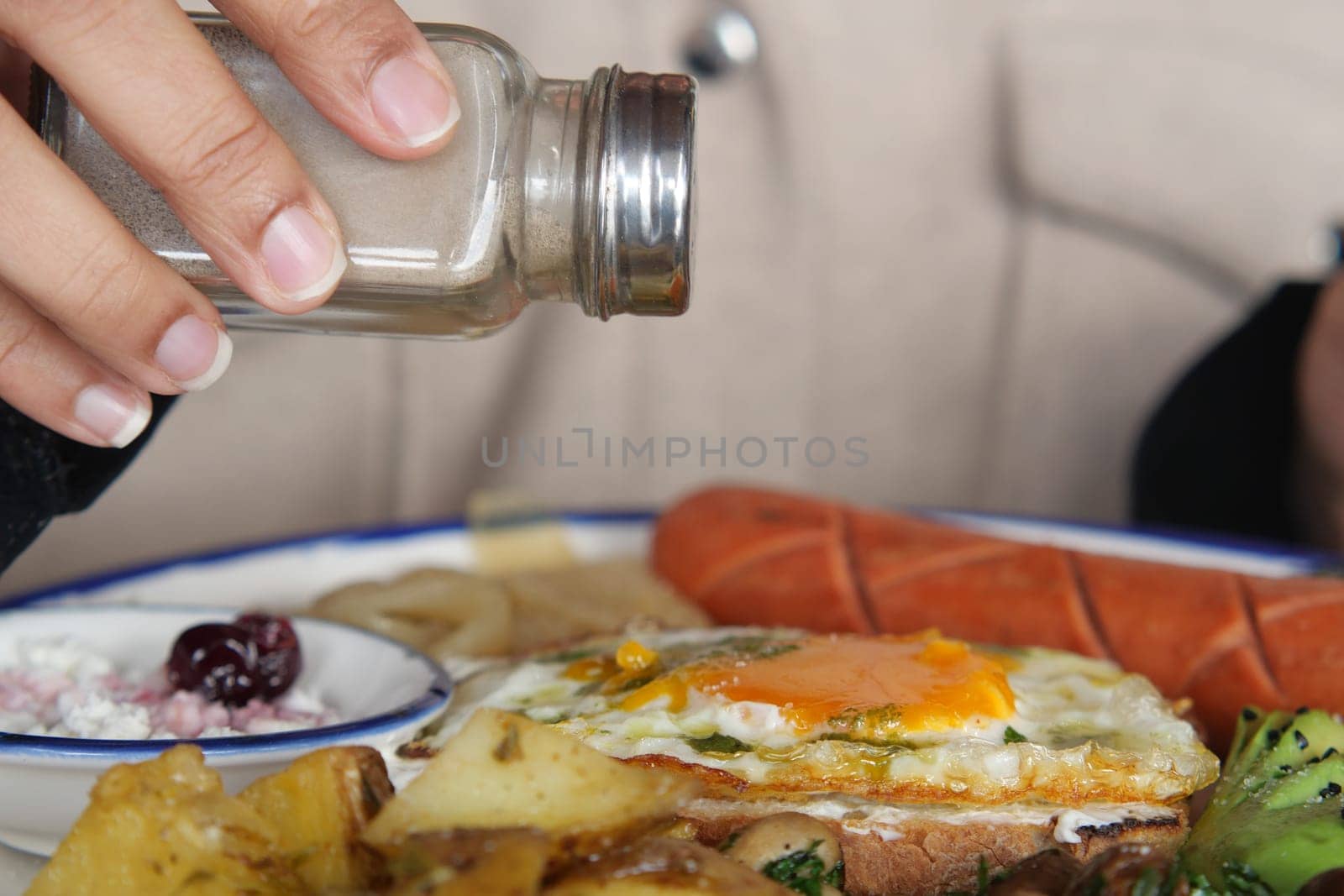 Adding Salt to a Delicious Breakfast Plate for Enhanced Flavor.