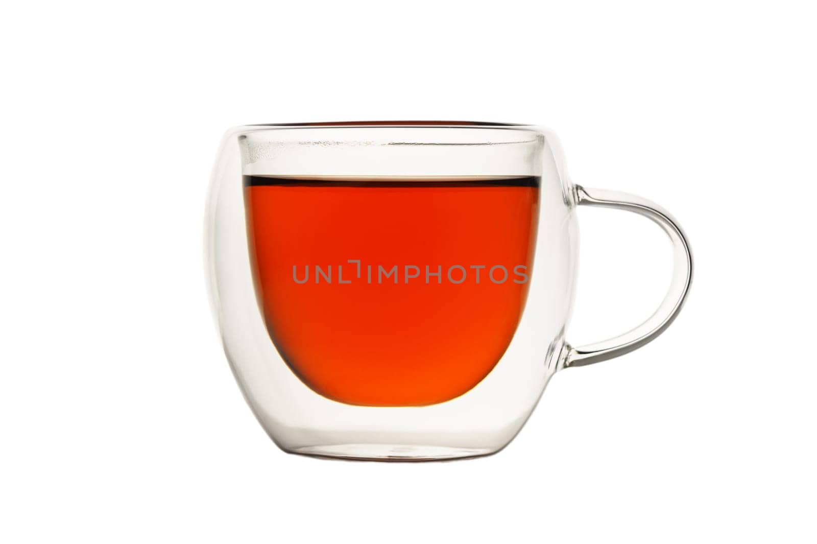 A clear glass cup holds rich amber tea, evoking a sense of comfort and tranquility during afternoon relaxation.