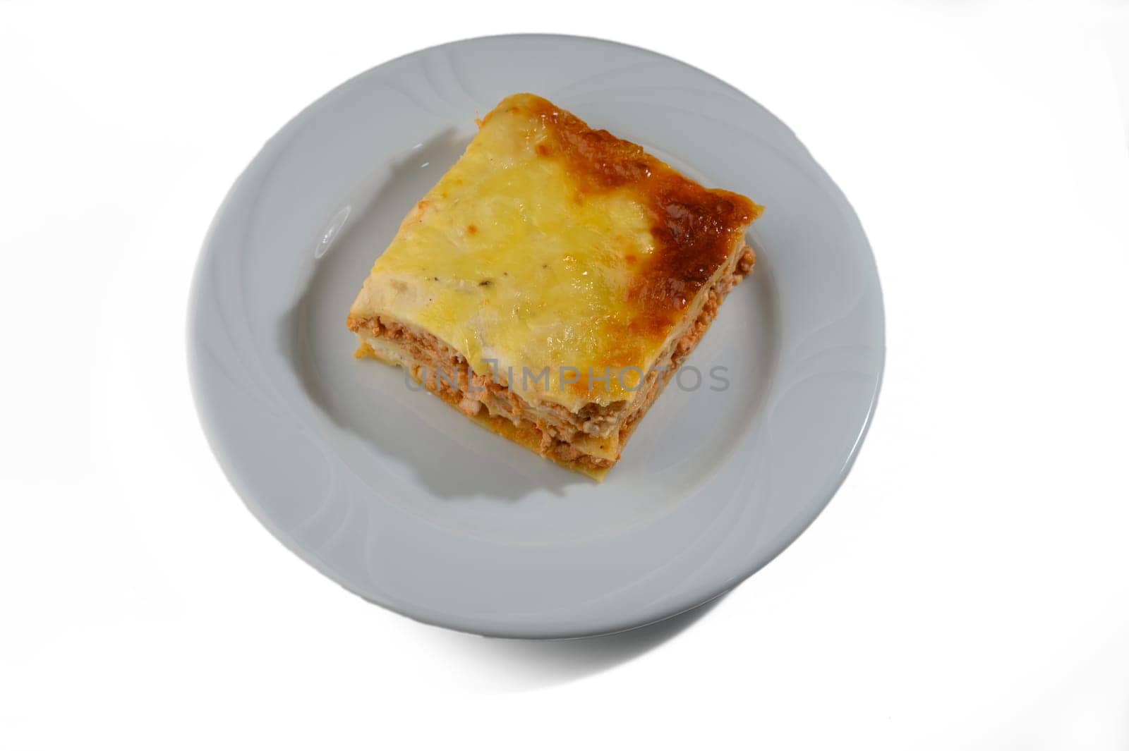 A hearty slice of lasagna rests on a plate, showcasing its rich layers of pasta, meat, and melted cheese.