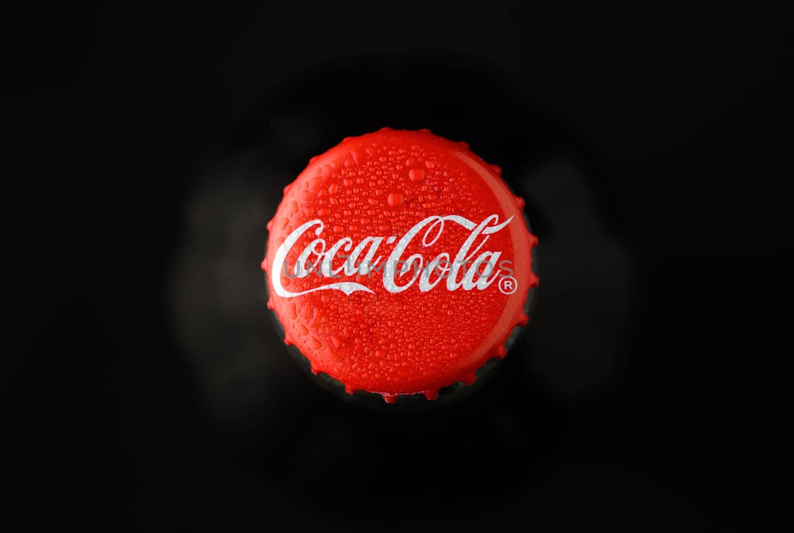 Gaziveren Cyprus -08.03.2025 Coca cola A vibrant red soda cap covered in beads of water shines brightly in the dark, inviting thirst and nostalgia.