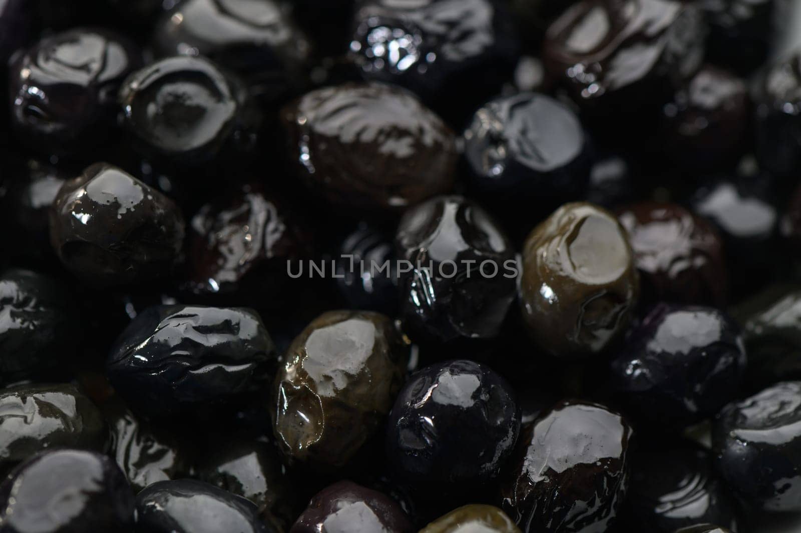 Lustrous black olives showcase their vibrant surfaces, awaiting to elevate dishes with rich flavor and texture.