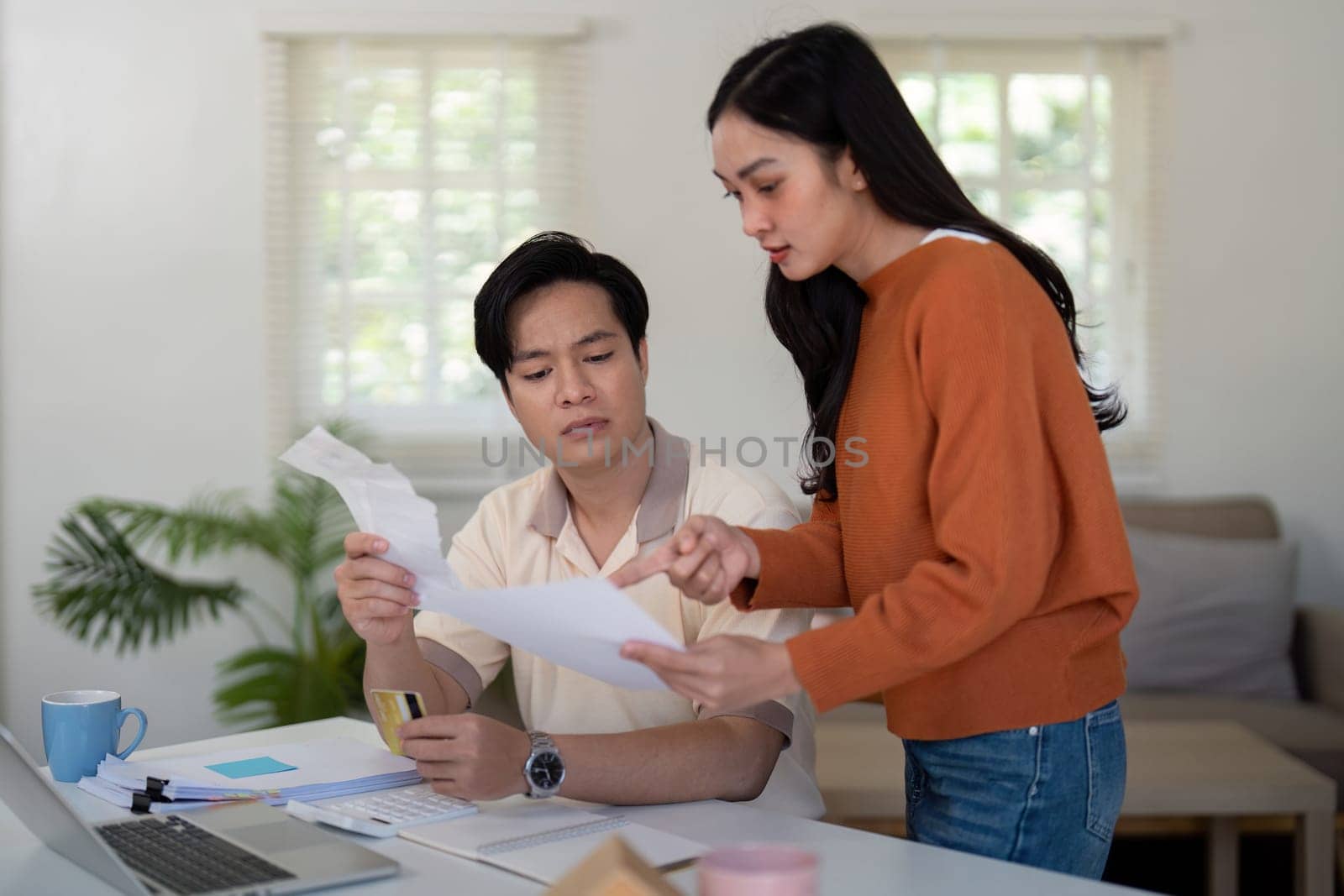 A couple engages in financial discussions, reviewing documents and sharing ideas to manage their budget effectively.