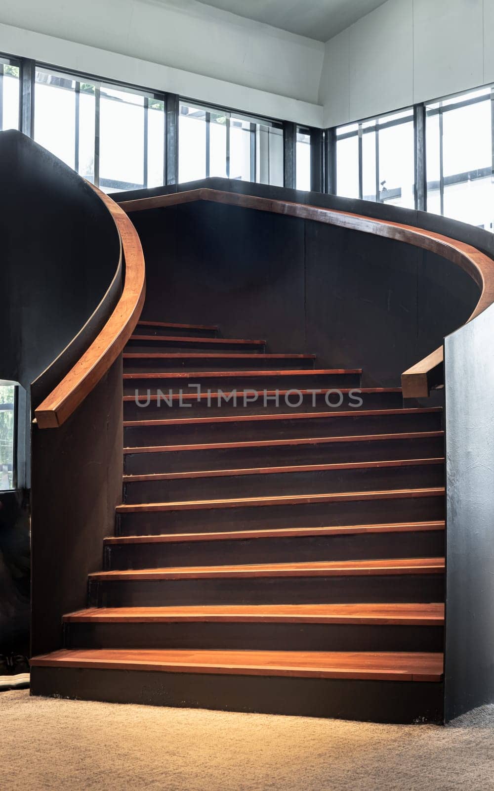 Bangkok, Thailand - Mar 02, 2025 - Layered wood spiral staircase with railings handle grip interior of Bank of Thailand Learning Center. View of Geometric shape of wooden curved stairs, Interesting architectural elements, use it as your Wallpaper, Poster and Space for text, Selective focus.