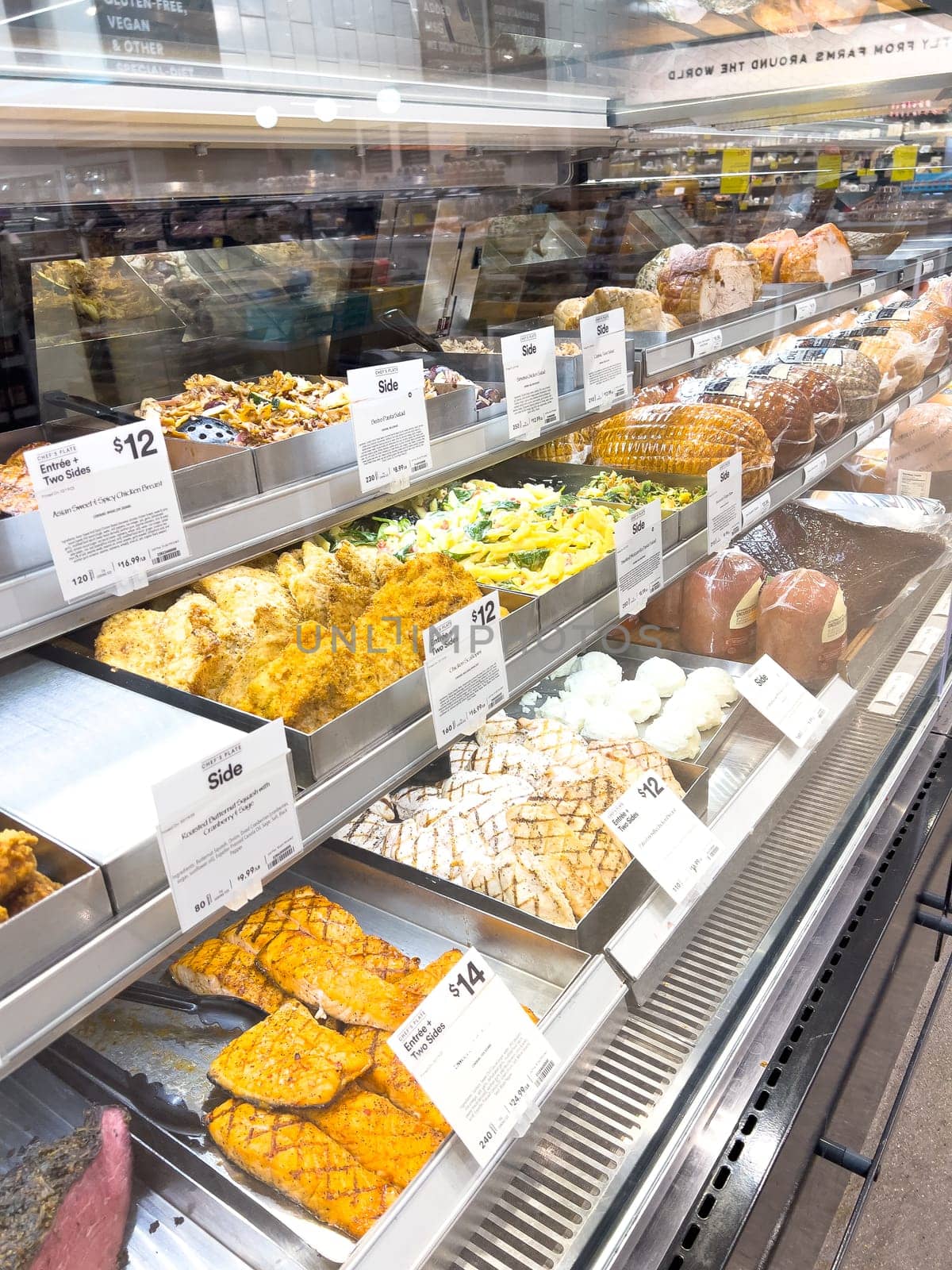 Castle Rock, Colorado, USA-February 22, 2025-A well-stocked Whole Foods deli case displaying a variety of fresh, prepared foods. The selection includes side dishes such as roasted vegetables, pasta salads, coleslaw, and other gourmet deli offerings. Each tray is labeled with pricing and descriptions, providing convenient meal options for customers.