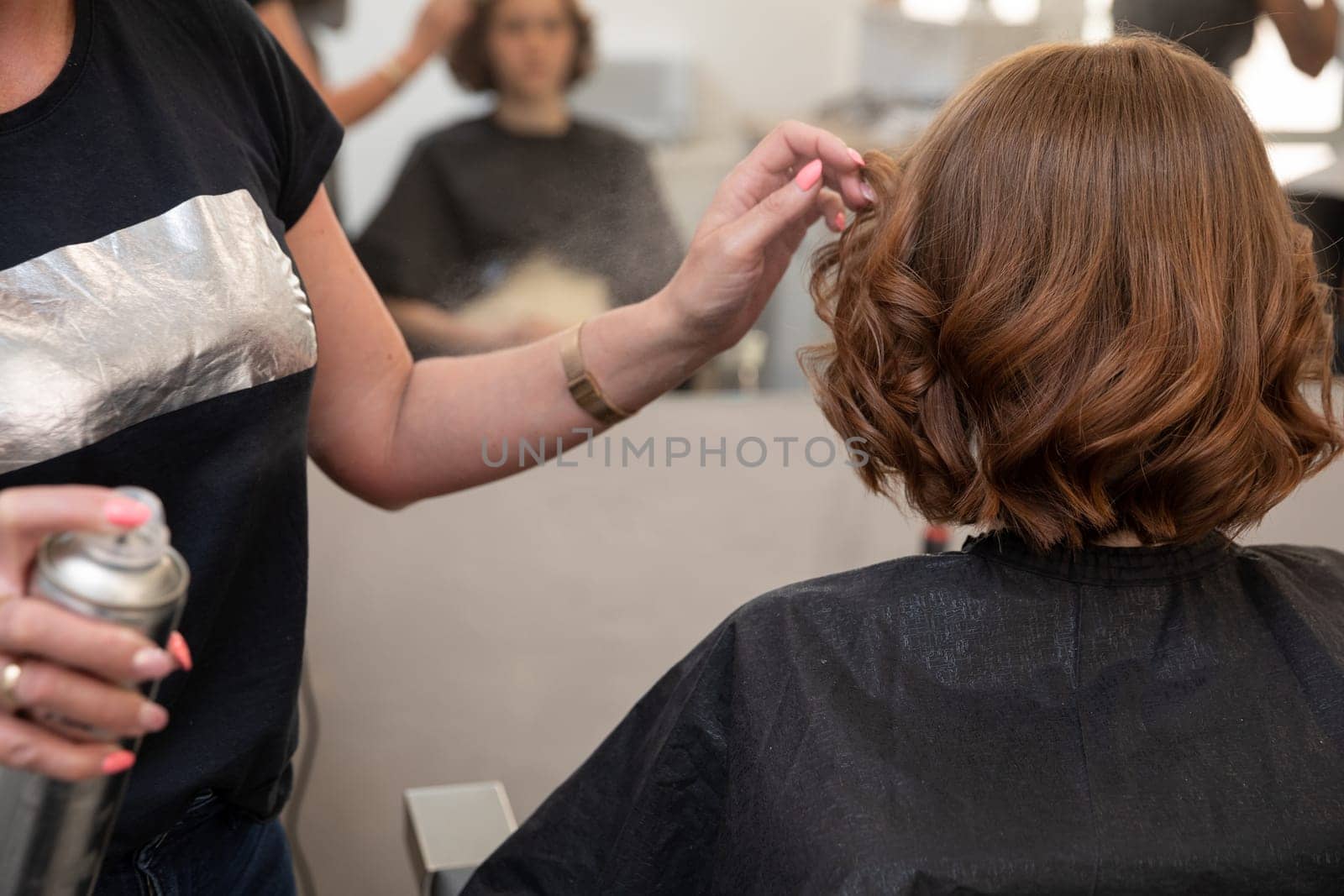 A skilled stylist enhances a clients hairstyle with precision and care in a chic salon environment