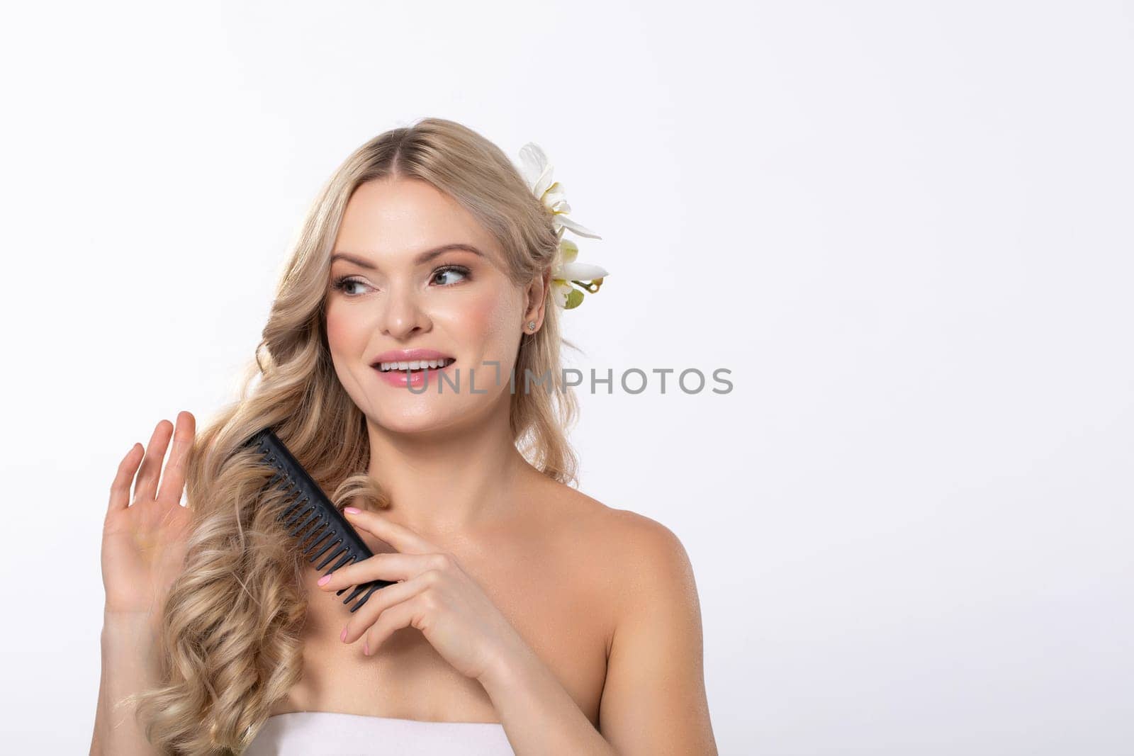 An elegant woman with long hair, holding a decorative comb, showcasing her natural beauty with poise