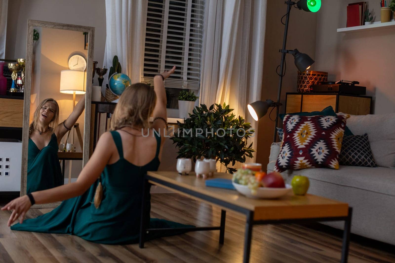 A beautiful, serene evening scene featuring a woman gracefully dancing in a warm, inviting, cozy living room