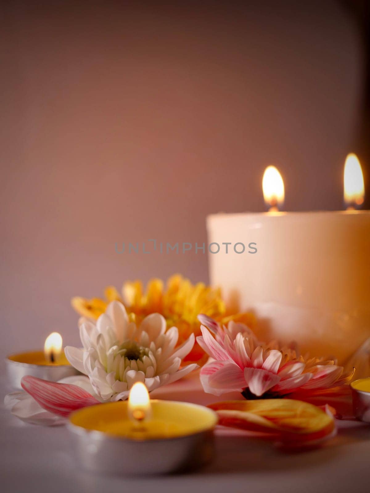Celebration of Diwali or Deepavali holiday in India with candles and flowers in the evening at night close-up. Hindus celebrate the festival of lights, vertical