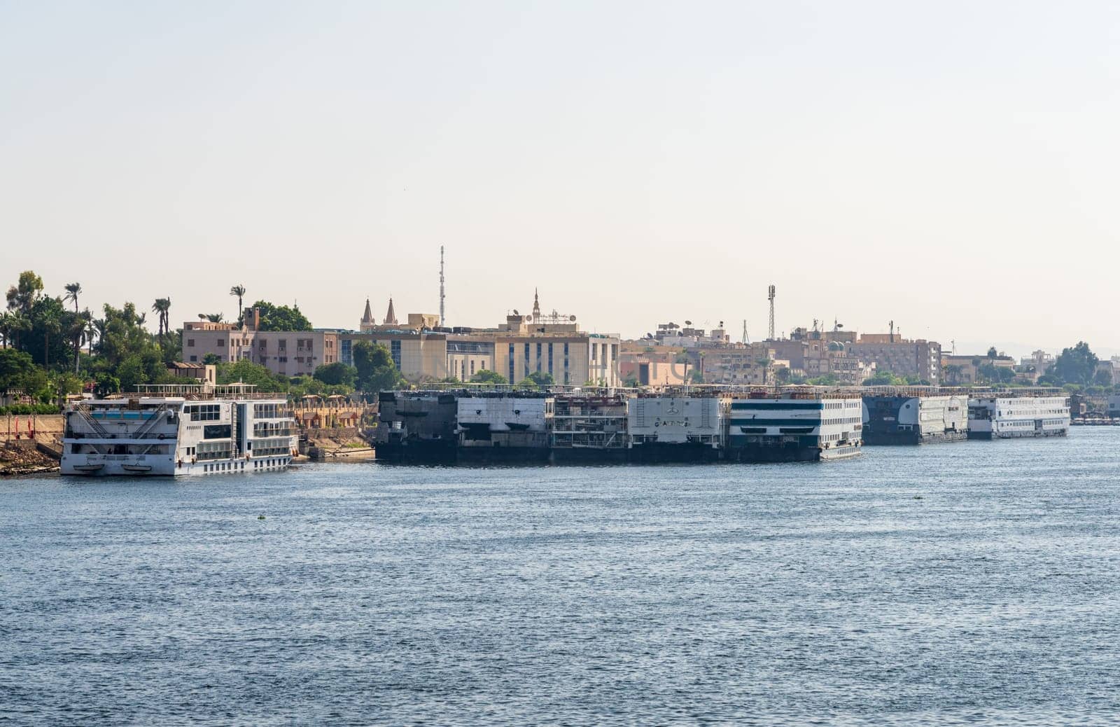 Luxor, Egypt - 2 November 2024: Many Nile River cruise ships are docked alongside each other along the shore of the Nile River