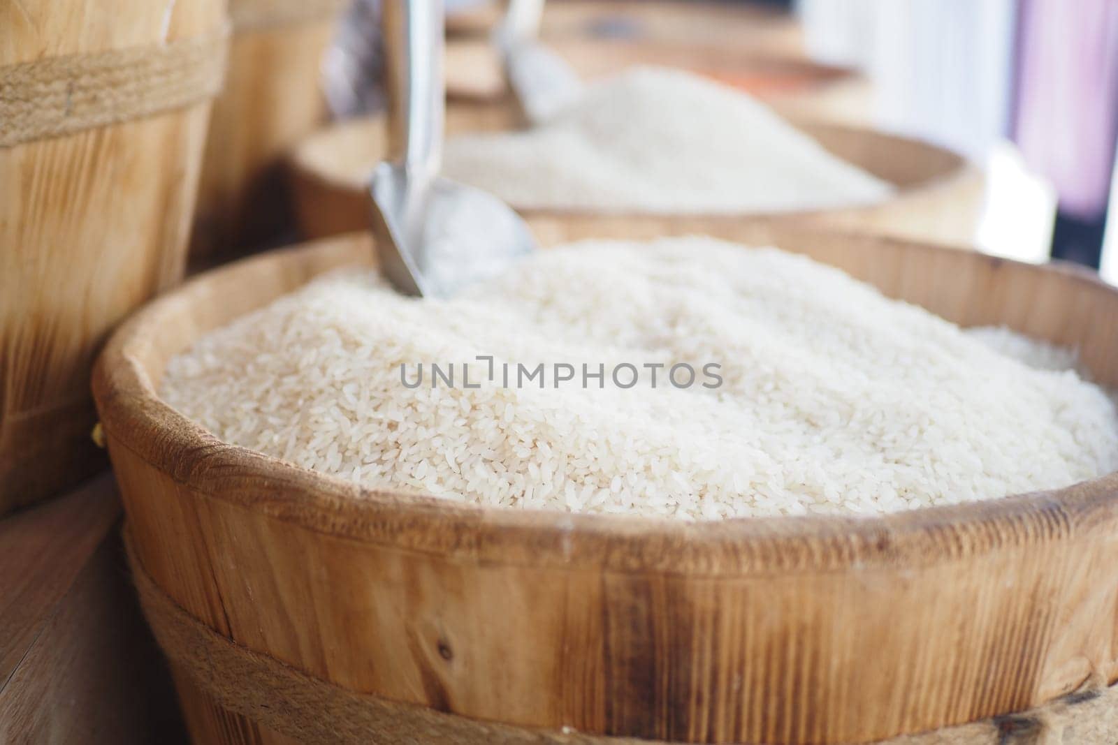 Baskets filled with white rice are arranged at a market stall for sale.