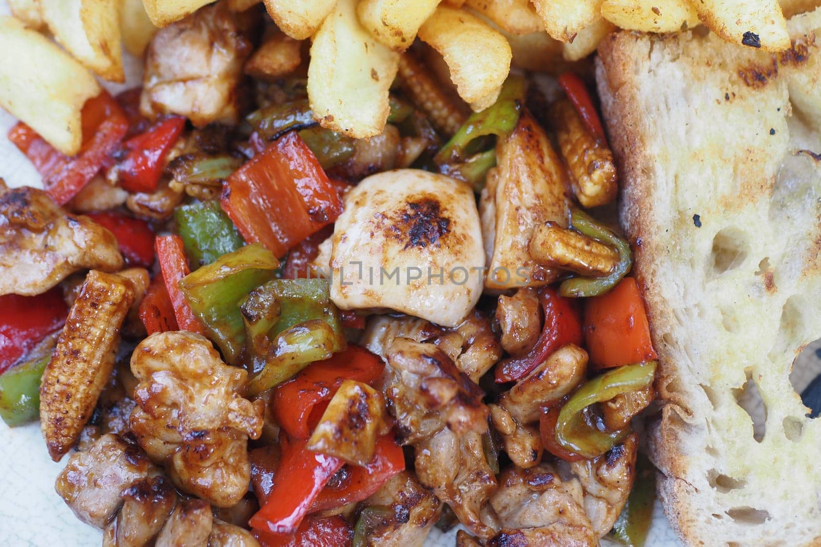 Juicy grilled chicken with colorful veggies and crispy fries.