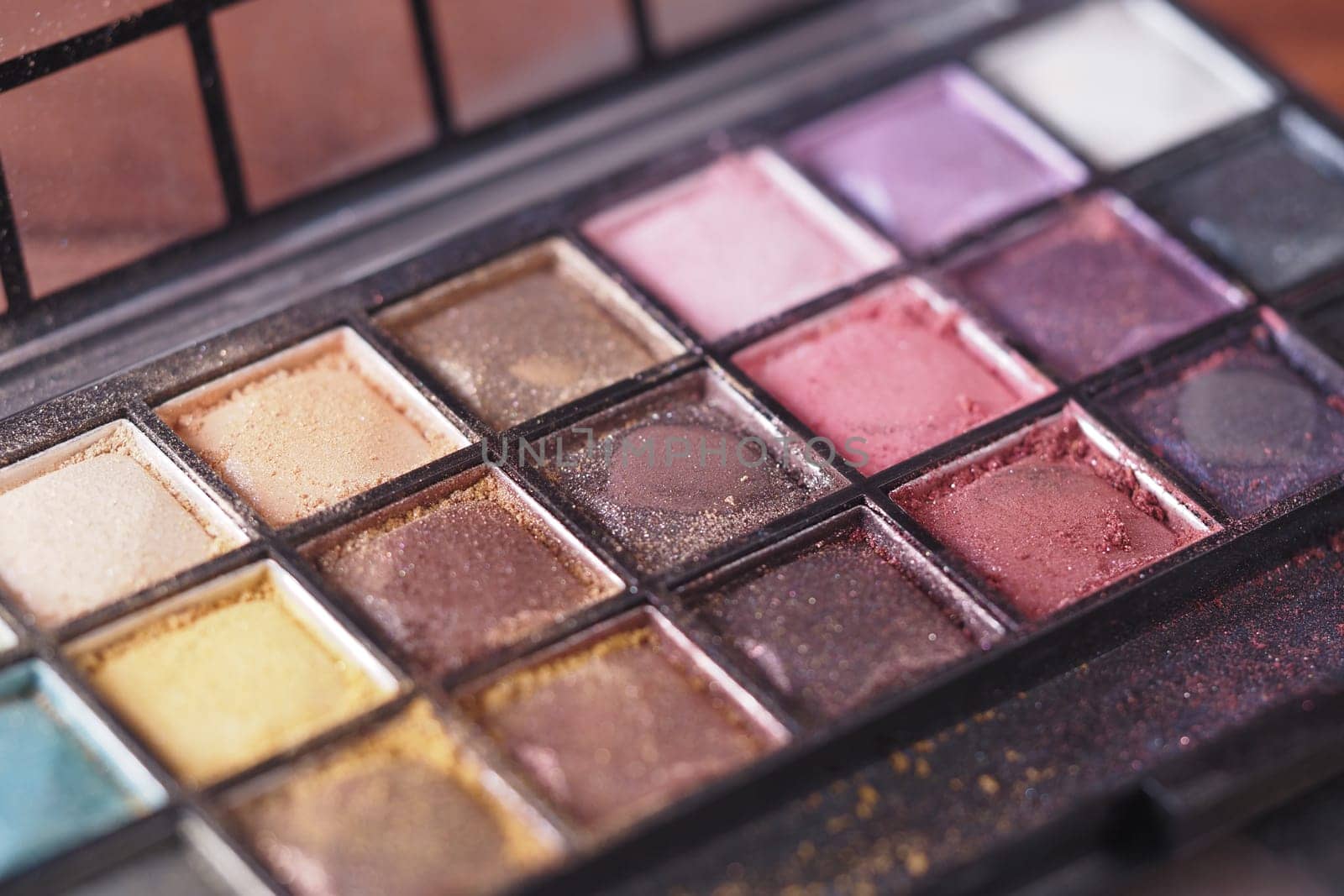 Close view of a makeup palette with diverse eyeshadow colors and finishes.