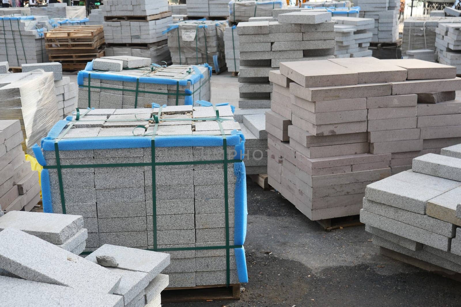Paving stones arranged in neat stacks at a busy construction area.