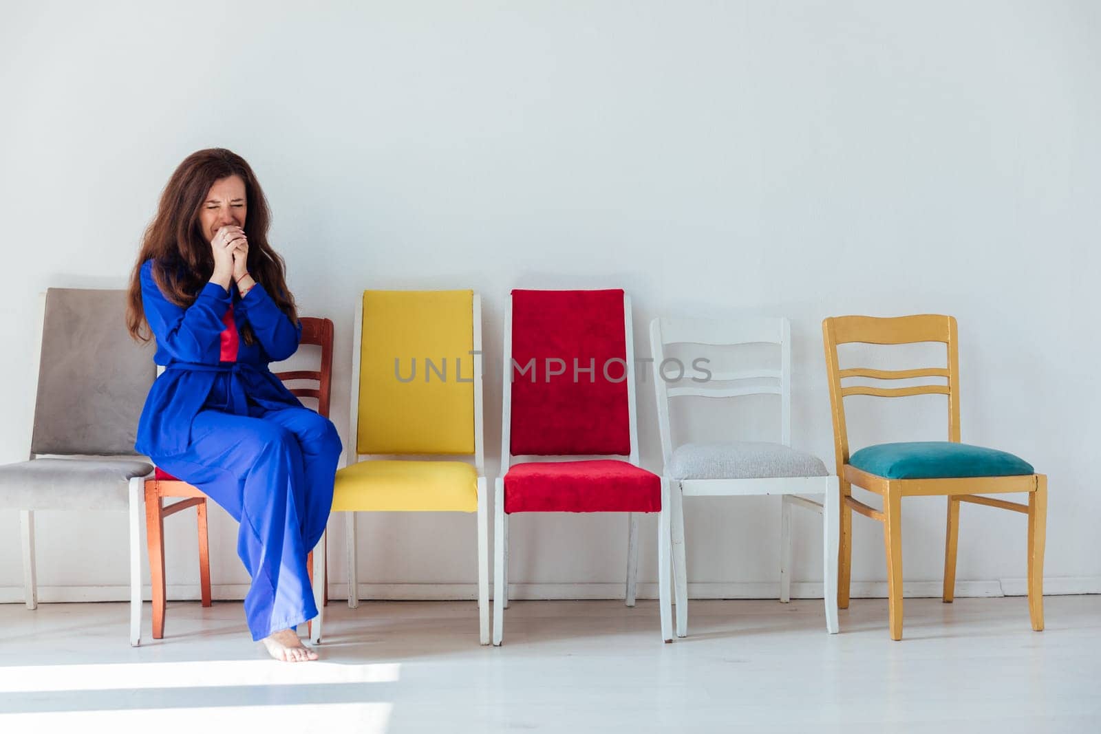 Woman in blue sitting on chairs in room interior