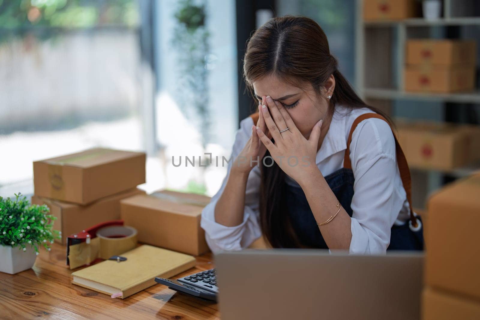 Young woman engaged in online business with stress thoughtful within data products Sales did not meet target Selling products of This month.