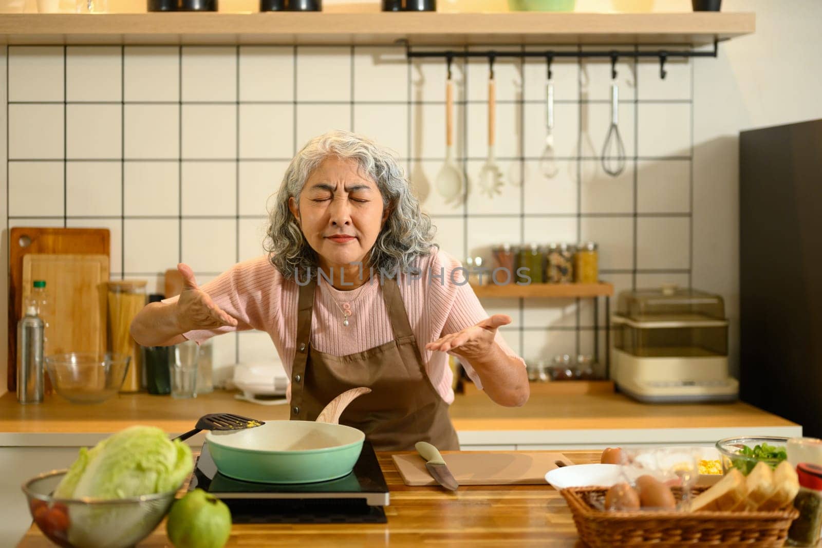 Happy senior woman preparing a simple breakfast in a modern kitchen.