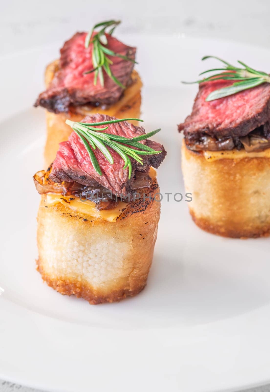 Crispy baguette filled with melted cheese, tender steak, sweet onions, and fresh rosemary