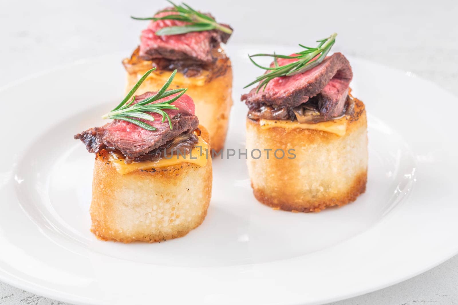 Crispy baguette filled with melted cheese, tender steak, sweet onions, and fresh rosemary