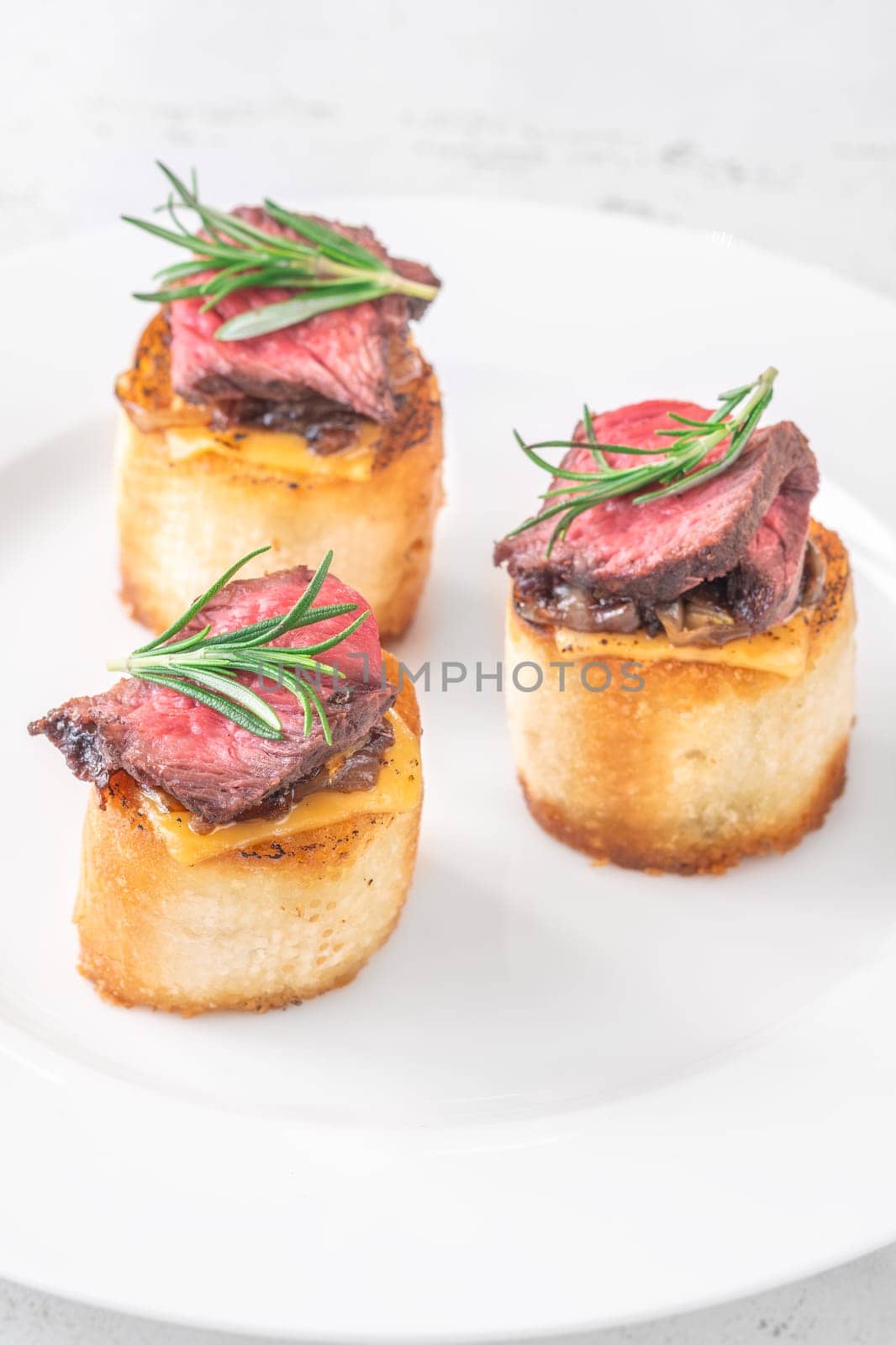 Crispy baguette filled with melted cheese, tender steak, sweet onions, and fresh rosemary