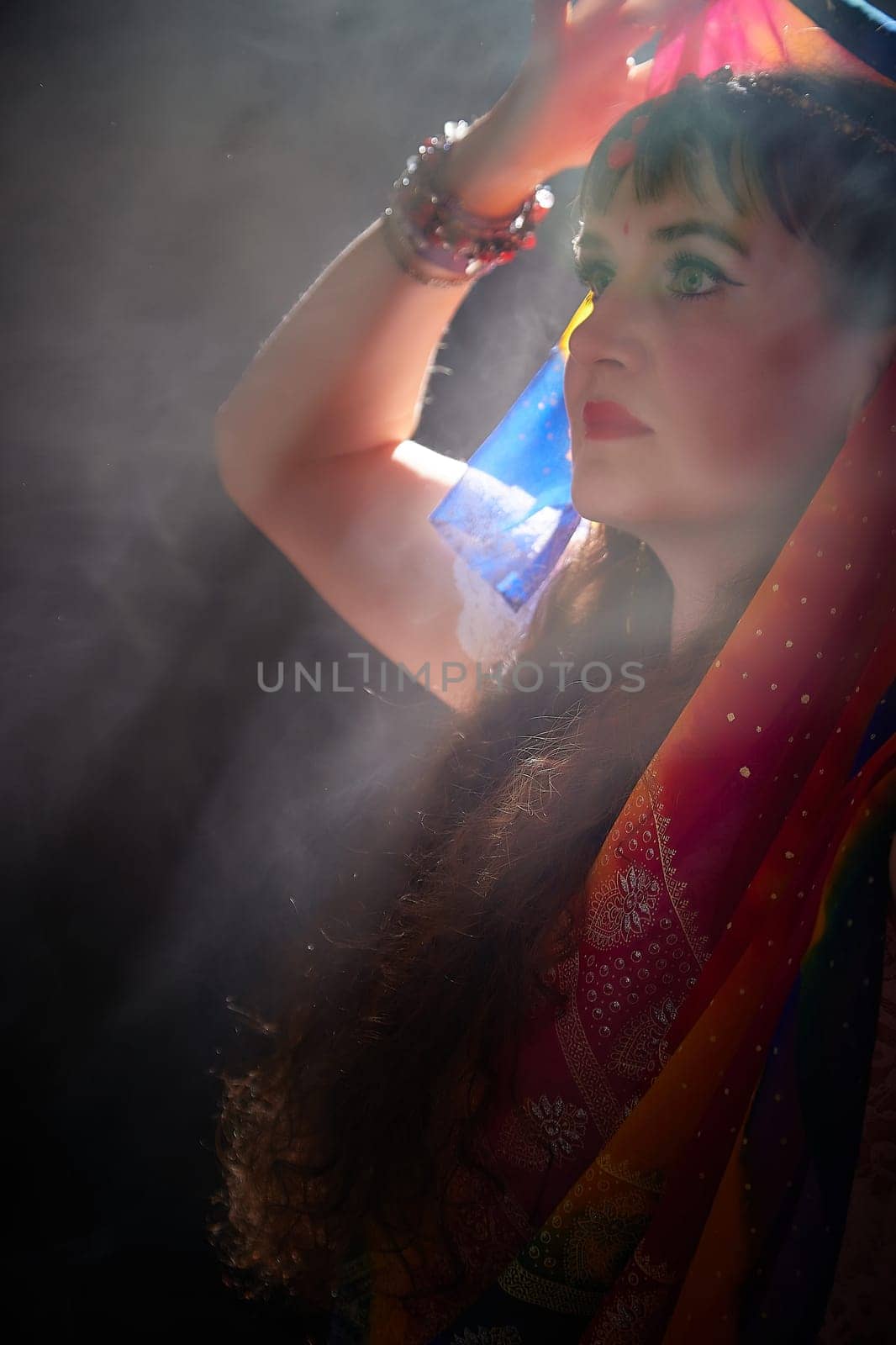 A middle-aged woman showcases her beauty in a vibrant sari, embodying Indian culture during a creative blogging session.
