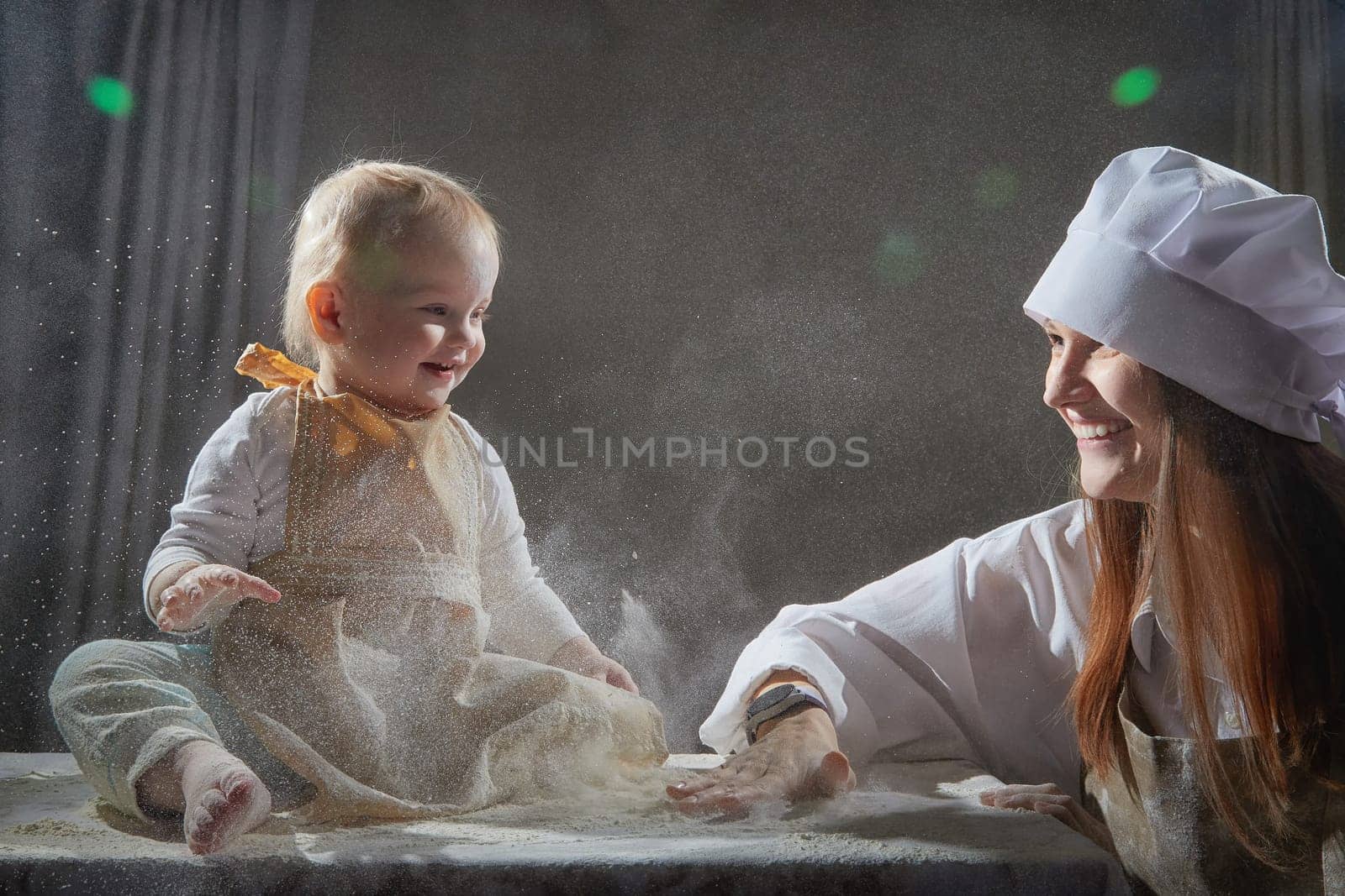 A mother and daughter joyfully engage in a flour-filled moment, creating memories in a cozy kitchen setting.