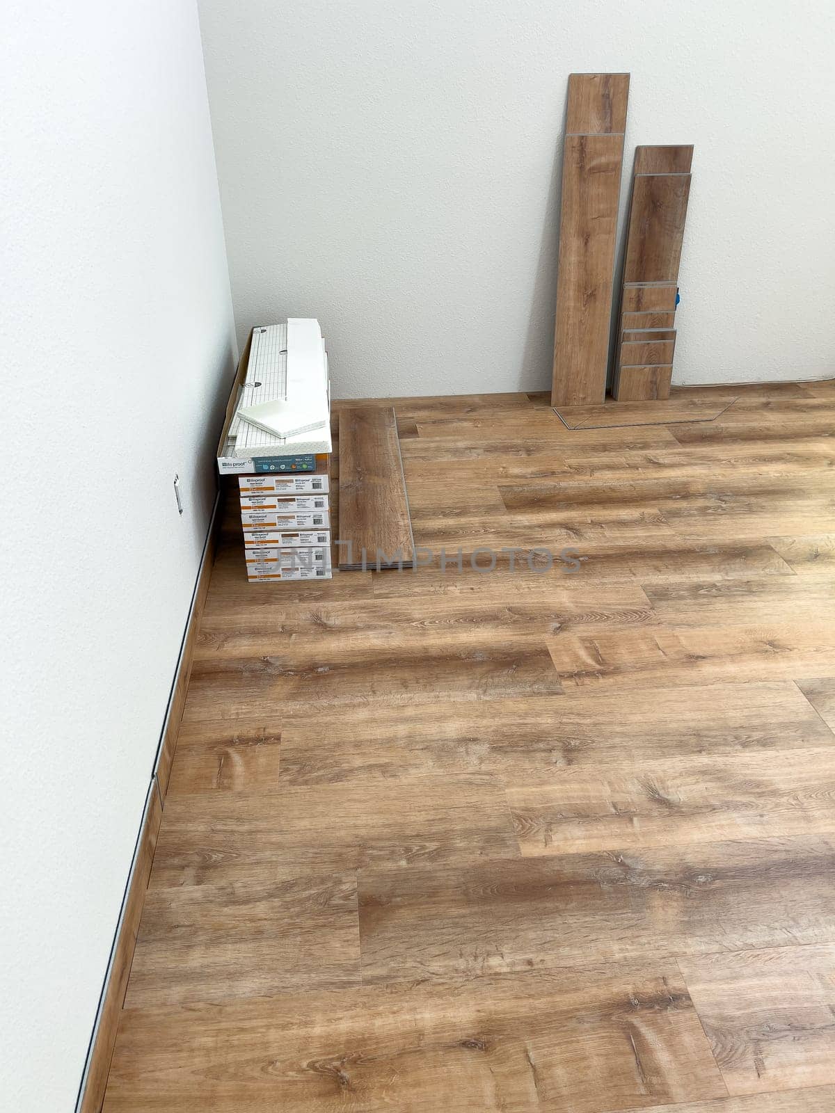 Broomfield, Colorado, USA-February 16, 2025-A room with newly installed wood-look flooring, with extra planks stacked against the wall. The flooring adds warmth and a modern touch to the space. The ongoing installation process suggests a home renovation or remodeling project.