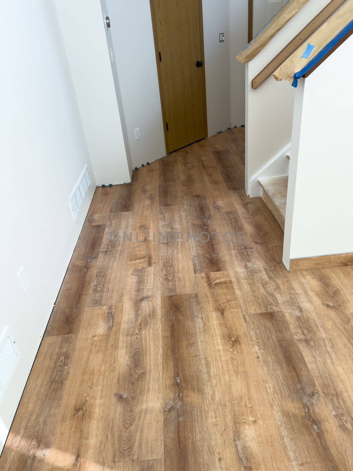 Broomfield, Colorado, USA-February 16, 2025-A kitchen with newly installed wood look flooring enhancing the space with a modern and warm aesthetic The flooring extends through the room complementing the wooden cabinetry Some underlayment remains visible indicating an ongoing home renovation project