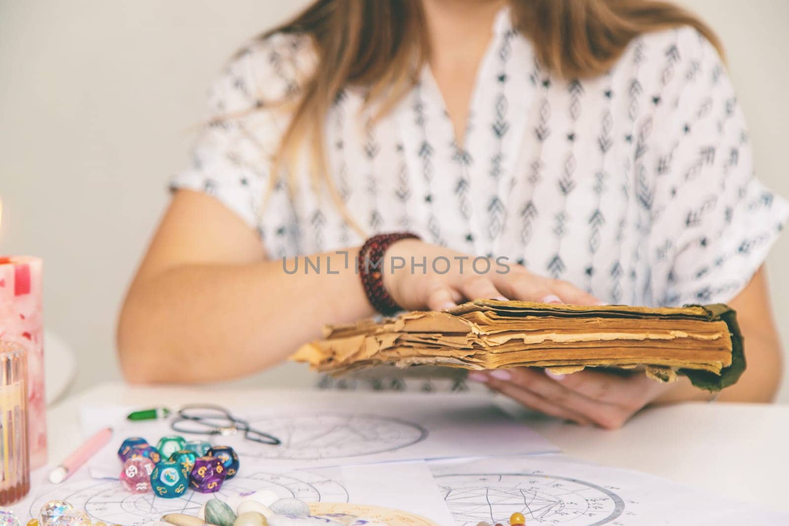 Woman fortune teller reads a book of spells. Selective focus