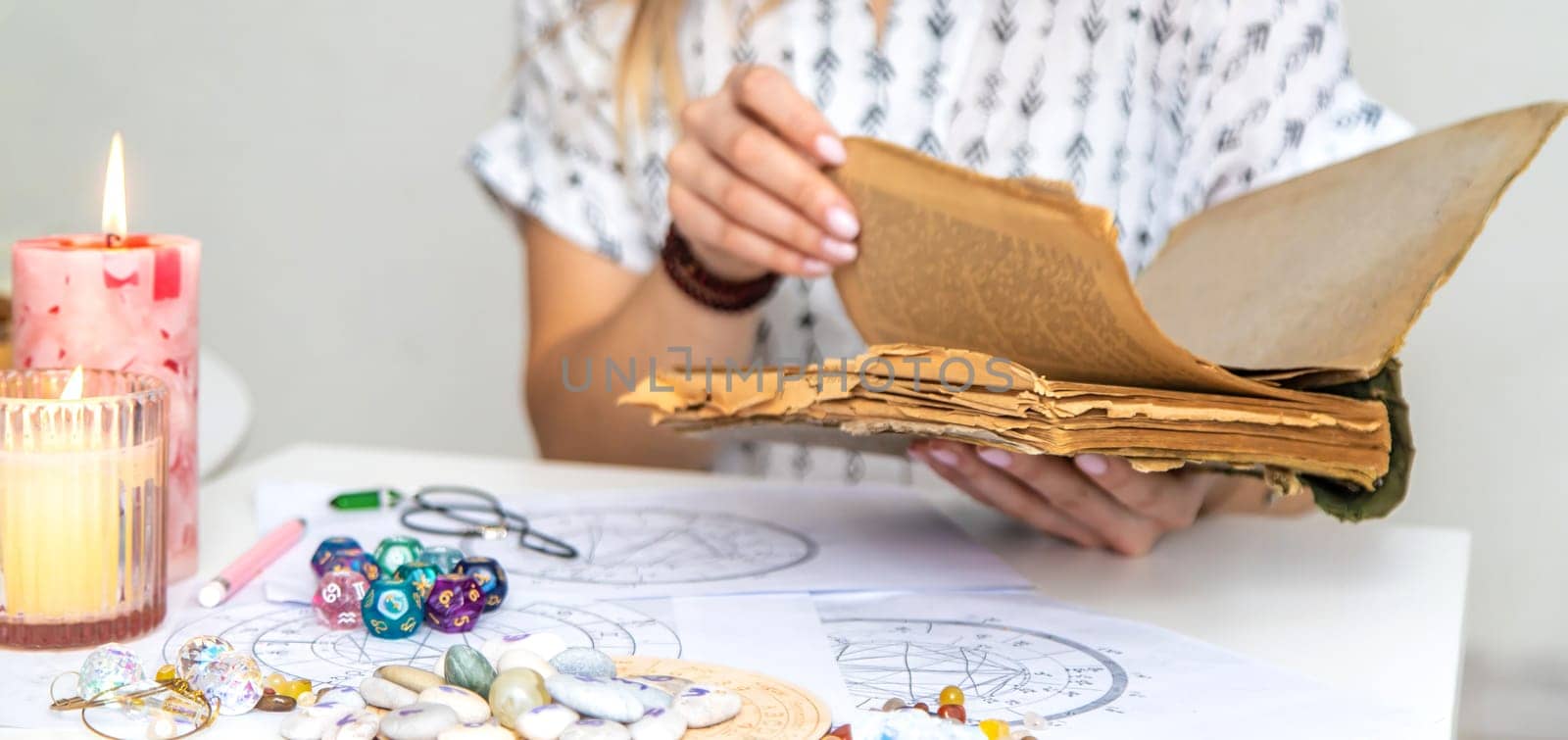 Woman fortune teller reads a book of spells. Selective focus