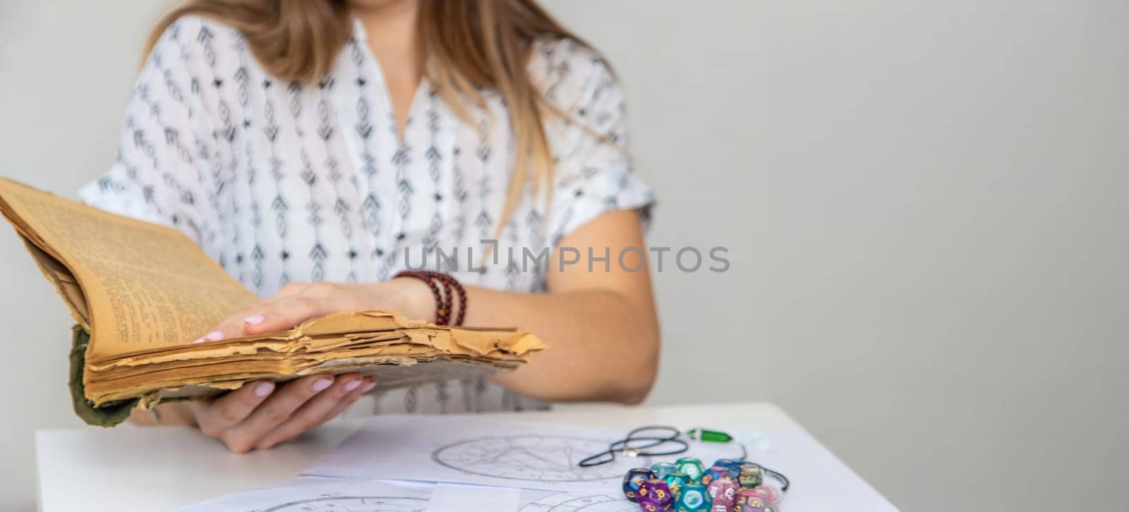 Woman fortune teller reads a book of spells. Selective focus