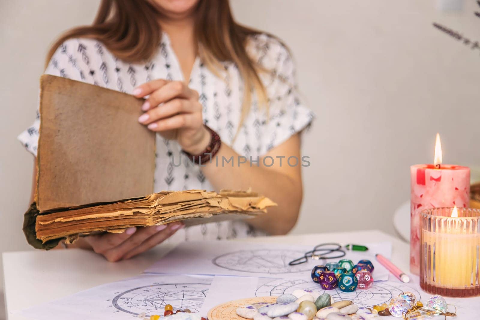 Woman fortune teller reads a book of spells. Selective focus