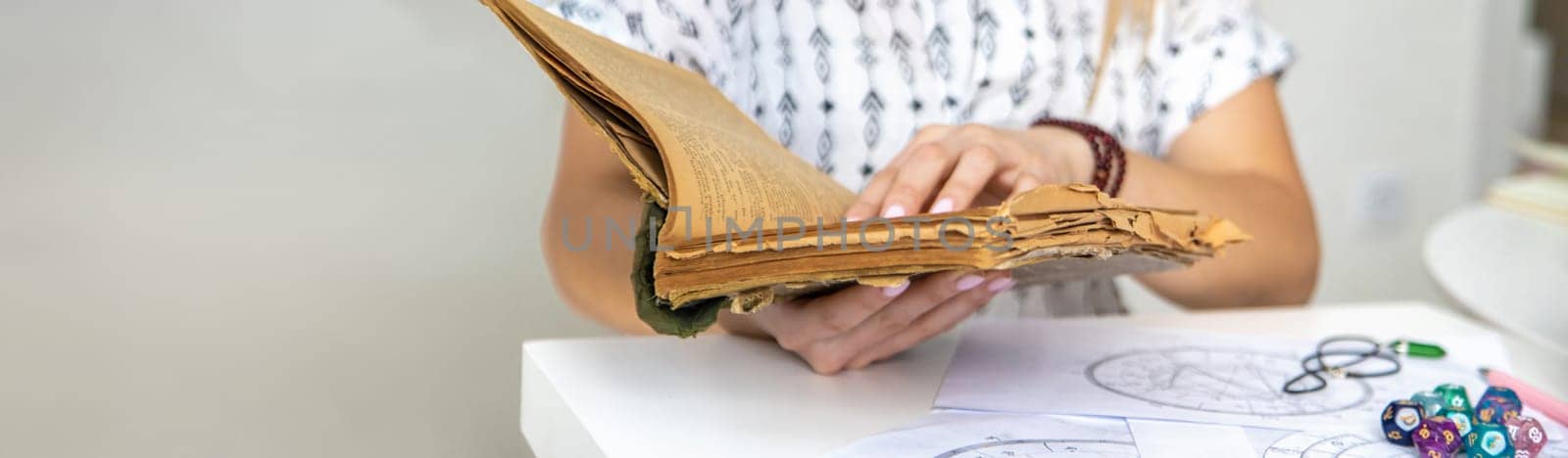 Woman fortune teller reads a book of spells. Selective focus