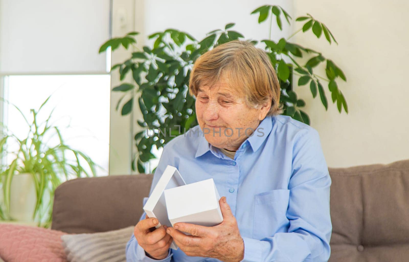 old woman holding a gift in her hands. Selective focus. senior