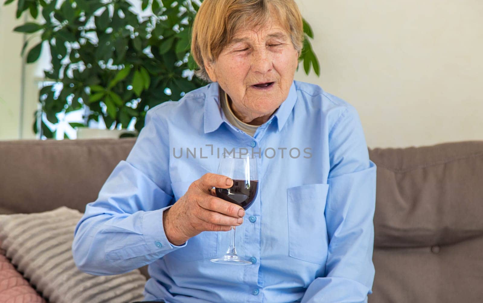 Old woman drinking wine. Selective focus. People,