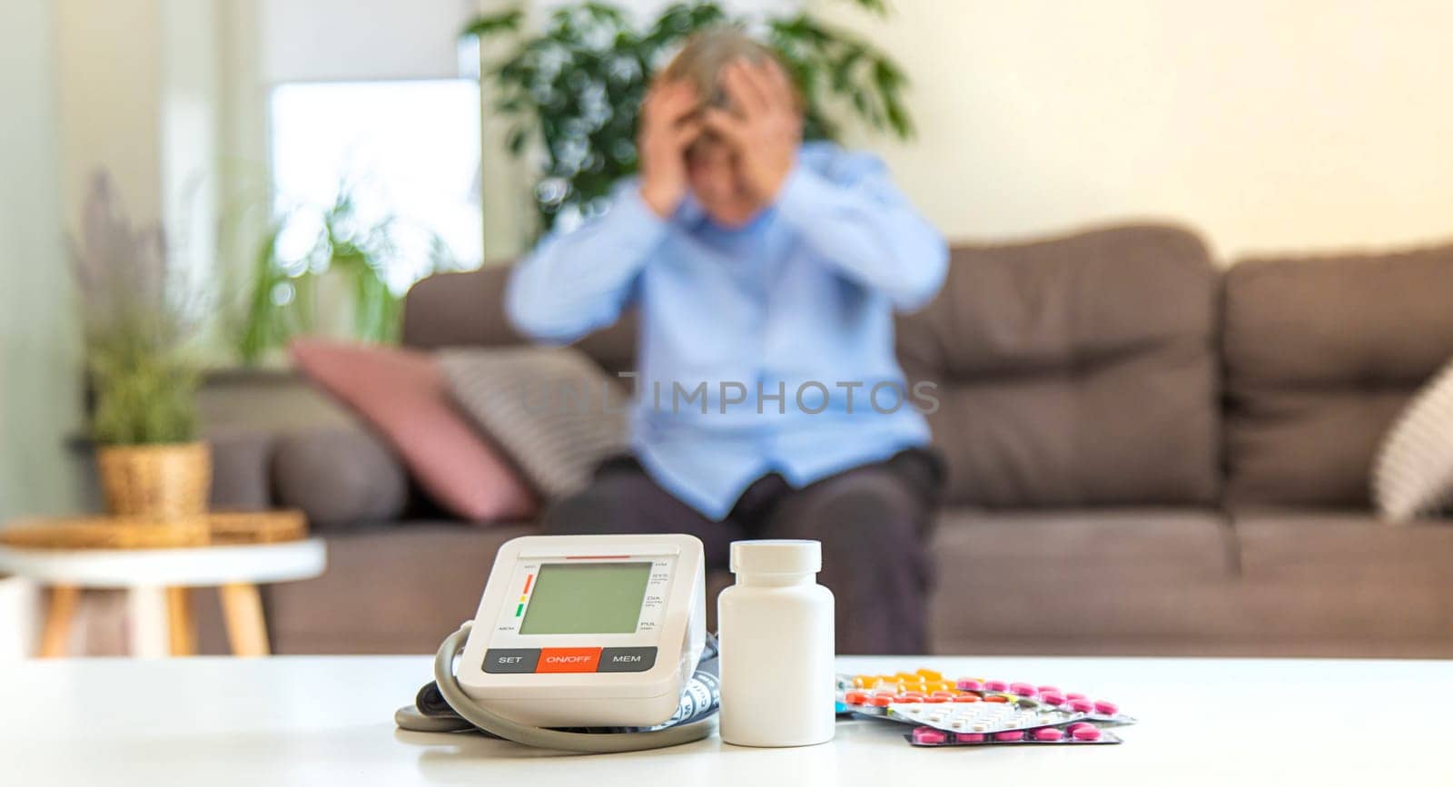 An old woman measures her blood pressure. Selective focus. people,