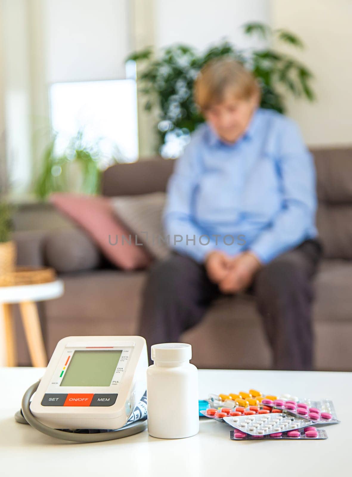 An old woman measures her blood pressure. Selective focus. people,