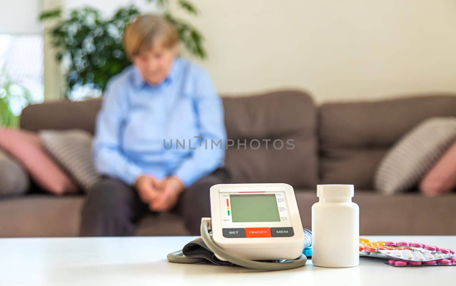 An old woman measures her blood pressure. Selective focus. people,