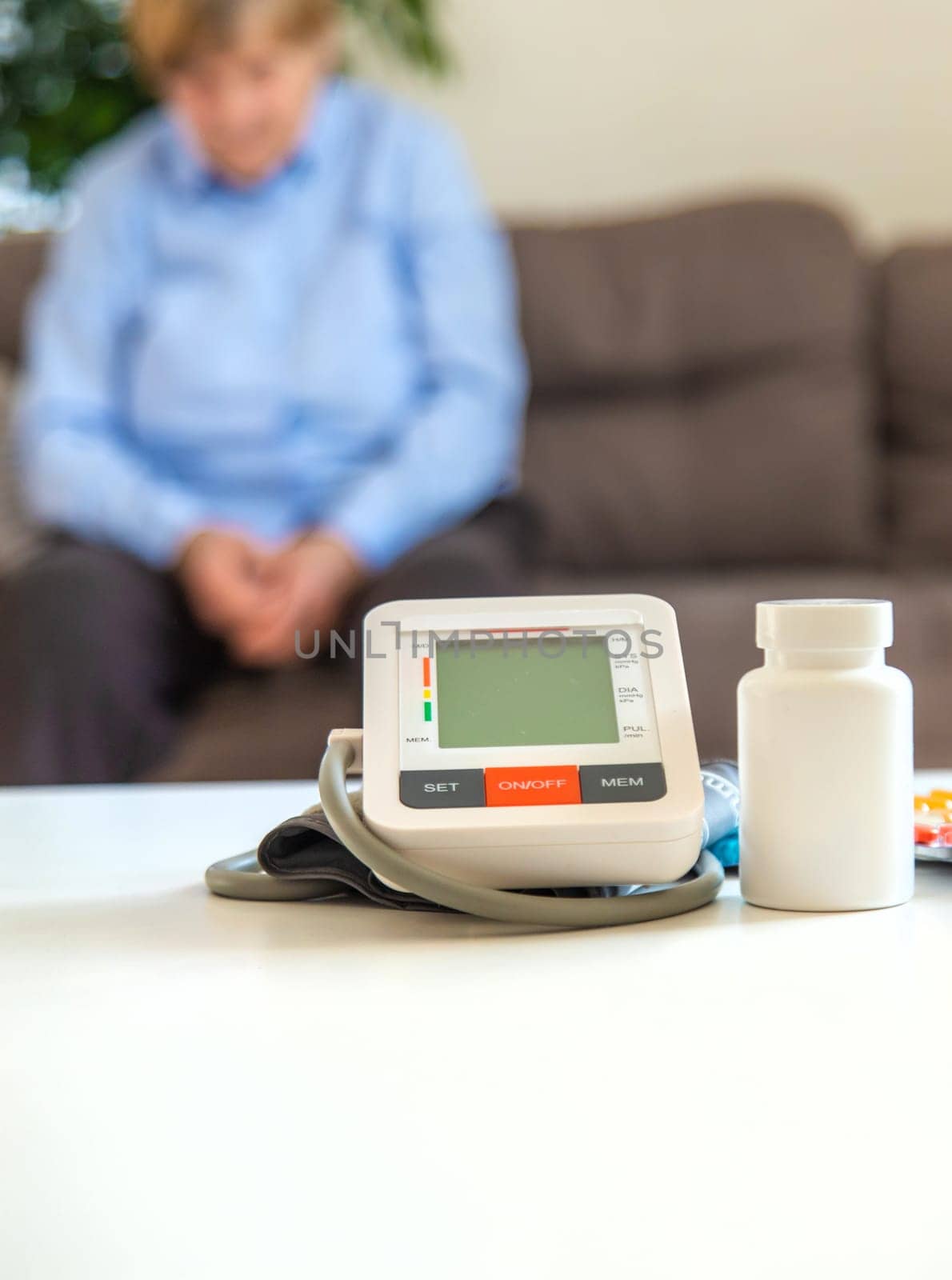 An old woman measures her blood pressure. Selective focus. people,