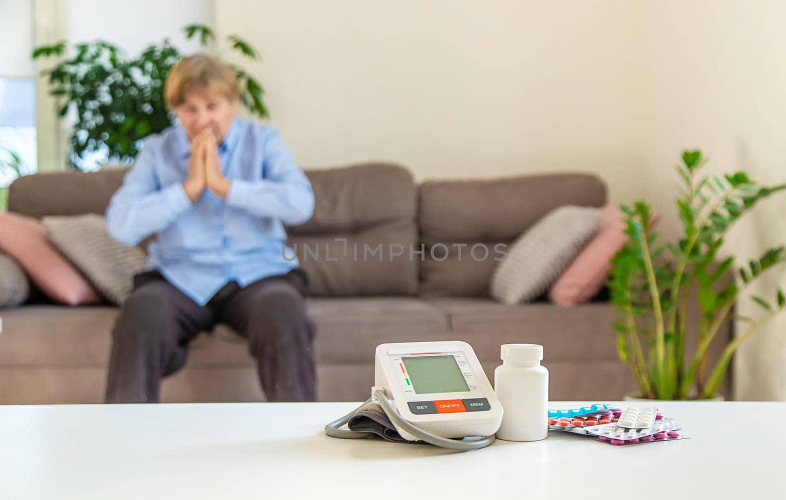 An old woman measures her blood pressure. Selective focus. people,